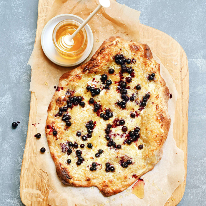 Gebirgsflammkuchen mit Bergkäse, Blaubeeren und Alpenrosenhonig