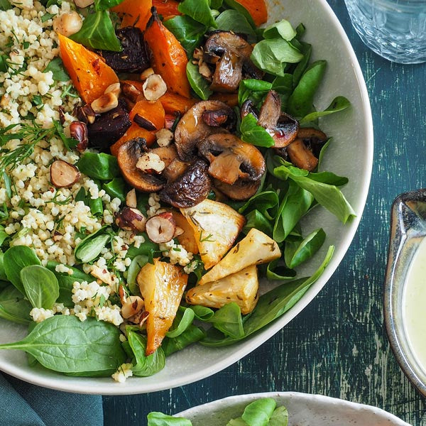 Kräuter-Hirse-Salatbowl mit Ofengemüse, fruchtigem Honig-Senf-Dressing und gerösteten Haselnusskerne