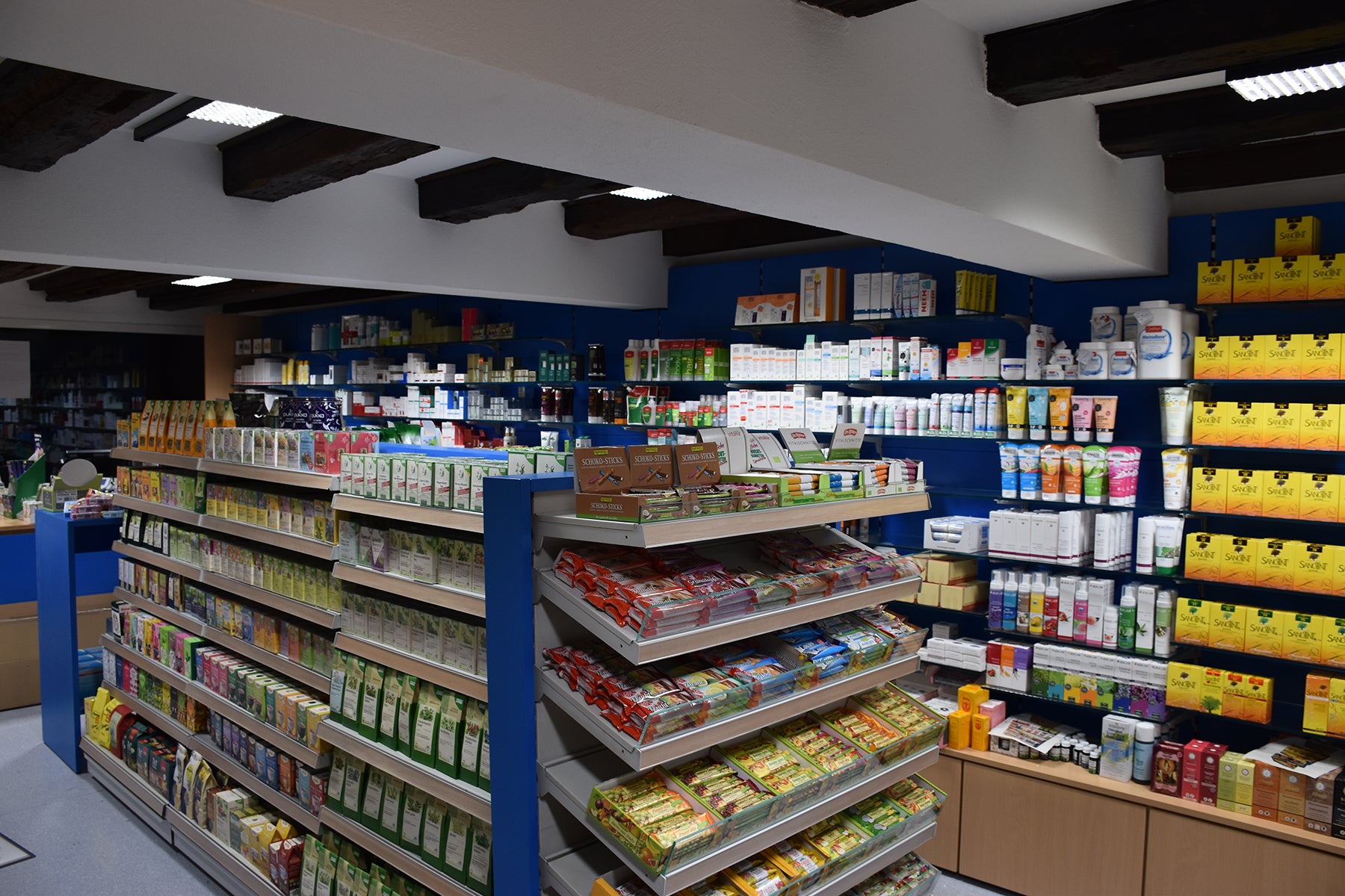 Regale mit verschiedenen Produkten. Tee, Süßwaren, Naturkosmetik