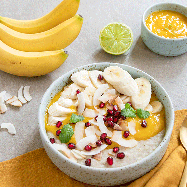 Exotische Frühstücks-Bowl mit Mangopüree und Granatapfelkernen