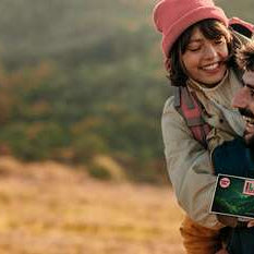 Junges PaarHuckepack in herbstlicher, bergiger Landschaft
