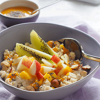 Hirse-Porridge mit Cashewmus-Sahne, frischen Früchten und Mango-Topping