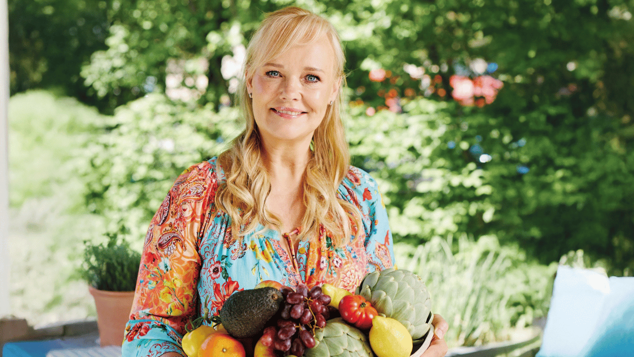 Dr. med. Franziska Rubin im Garten mit Obst- und Gemüseschale
