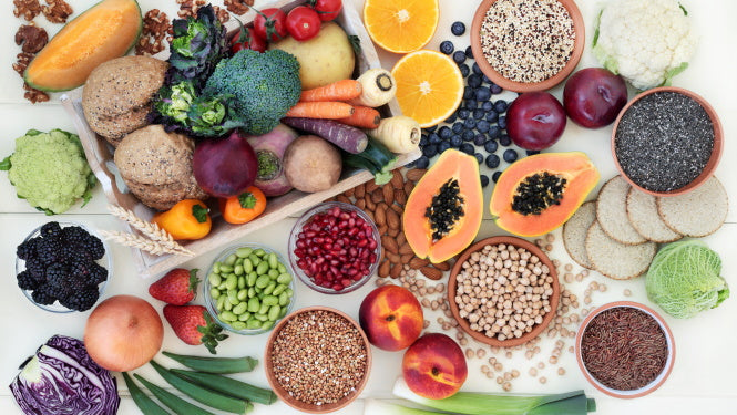 Flatlay: Buntes, unterschiedliches Obst und Gemüse, Saaten, Kerne, Hülsenfrüchte ansprechend auf weißem Untergrund arrangiert