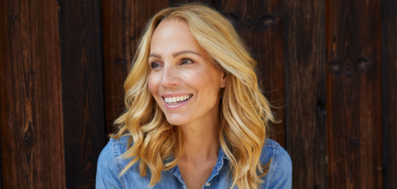 Lächelnde Frau vor Holzwand