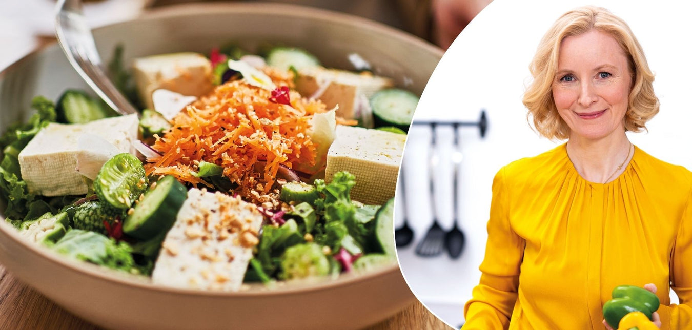 Anne Fleck in gelber Bluse und einer frischen Bowl mit grünem Gemüse, Karottenraspel und Tofuwürfeln