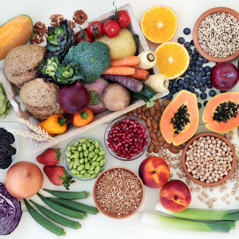 Flatlay: Buntes, unterschiedliches Obst und Gemüse, Saaten, Kerne, Hülsenfrüchte ansprechend auf weißem Untergrund arrangiert