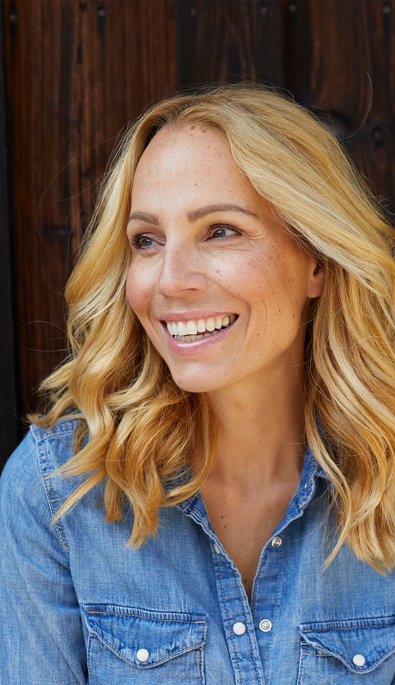 Lächelnde Frau vor Holzwand