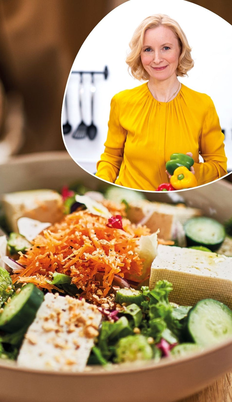 Anne Fleck in gelber Bluse und einer frischen Bowl mit grünem Gemüse, Karottenraspel und Tofuwürfeln