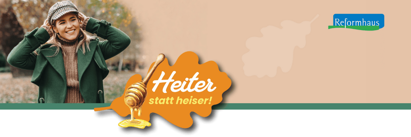 Junge Frau mit Kappe und grünem Mantel in herbstlicher Stimmung plus Claim "Heiter statt heiser!"