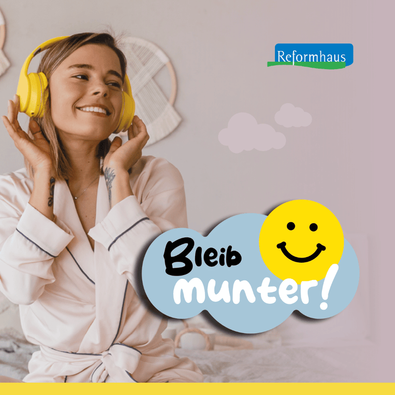 Lächelnde Frau im Pyjama mit gelben Kopfhörern plus Motto "Bleib munter!"